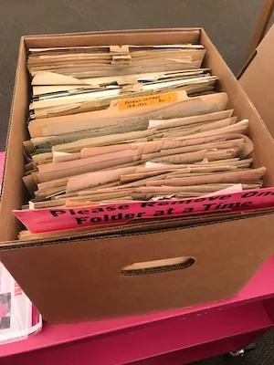 Photograph of a box with many old papers in it. One small folder is labeled 'Selection of Interesting Patient Letters'